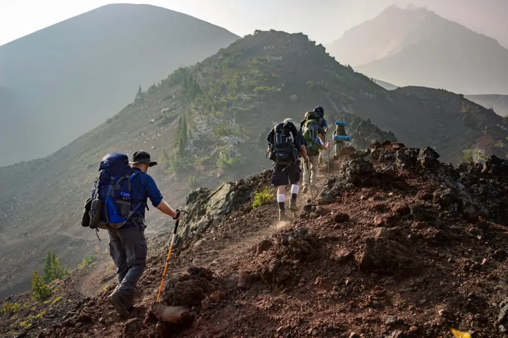 Group of hikers trekking on a rugged mountain trail in Oregon's scenic outdoors.