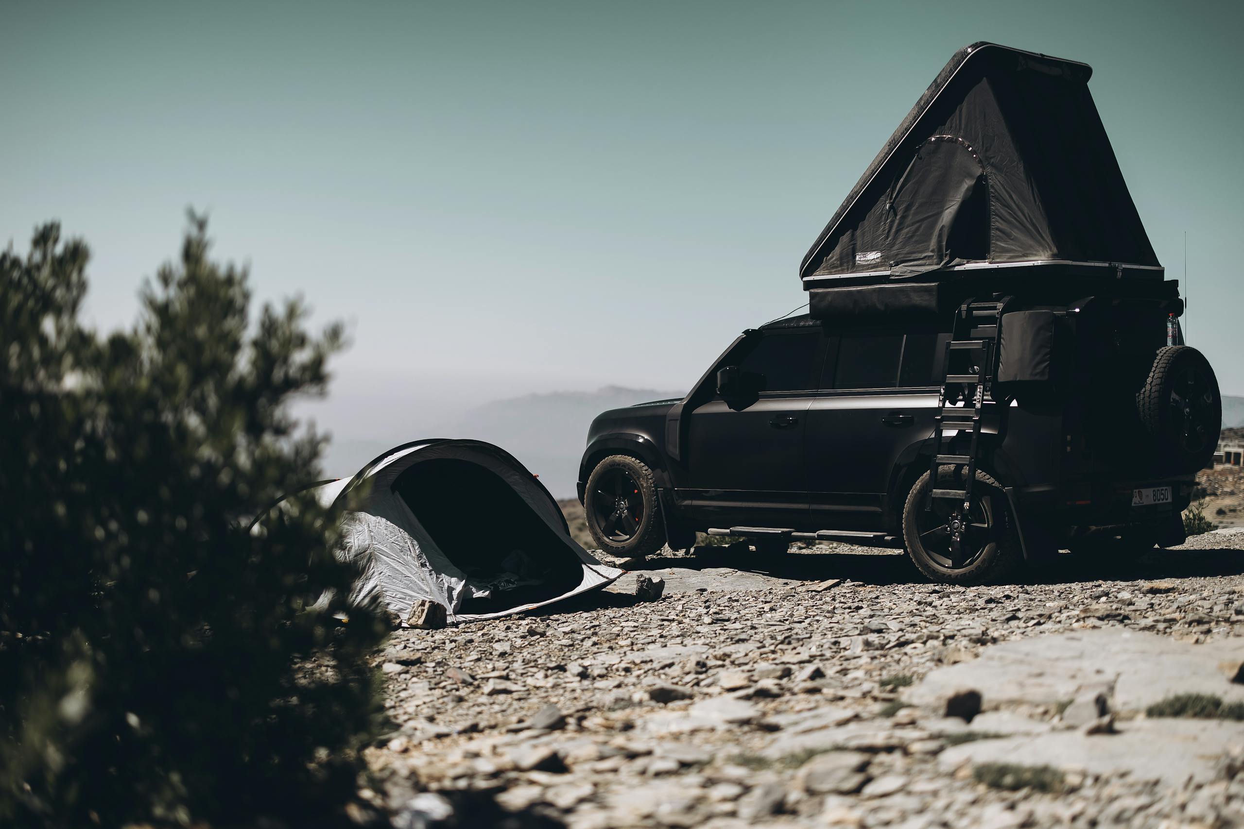 A 4x4 with rooftop tent setup in Oman's mountainous terrain, ideal for adventure travel.